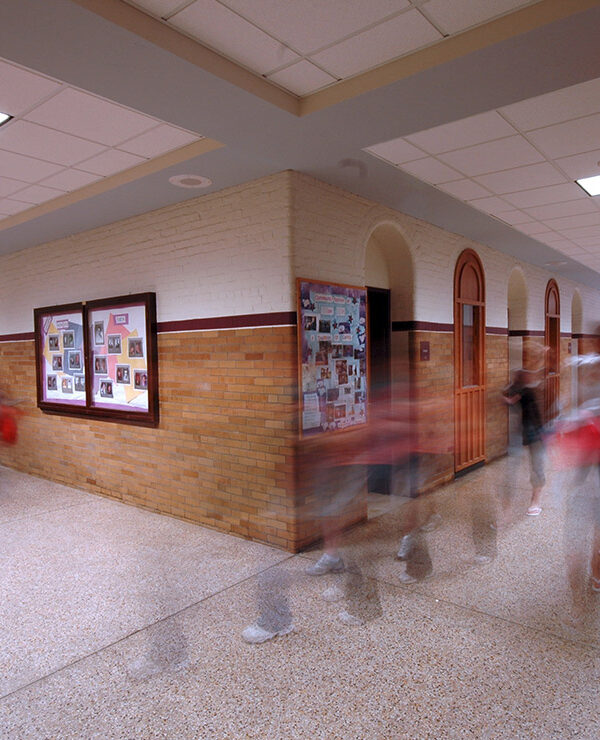 A group of kids moving in a school hallway.