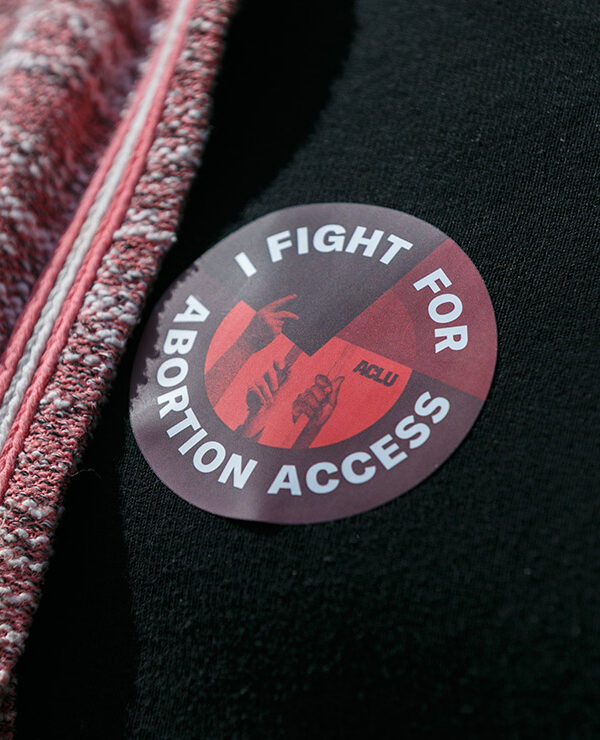 Someone wearing a sticker that says "I Fight For Abortion Access."
