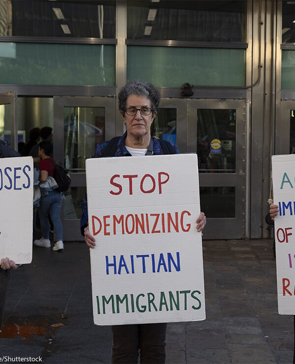 Anti-demonization of immigrants demonstrators hold signs that reads 'NO ONE CHOOSES TO BE A REFUGEE' 'STOP DEMONIZING HAITIAN IMMIGRANTS' 'ACCUSING IMMIGRANTS OF EATING PETS IS AN OLD RACIST LIE.