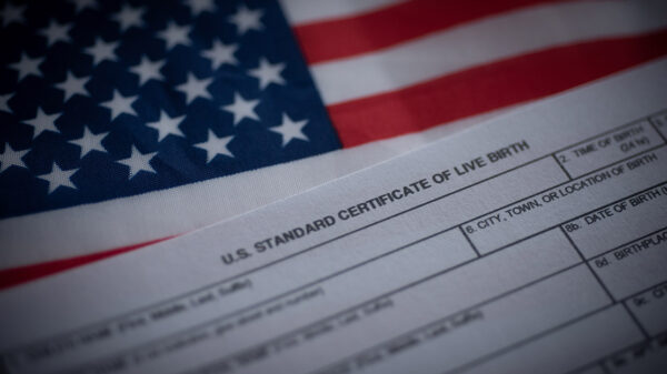 A birth certificate in front of an American flag.