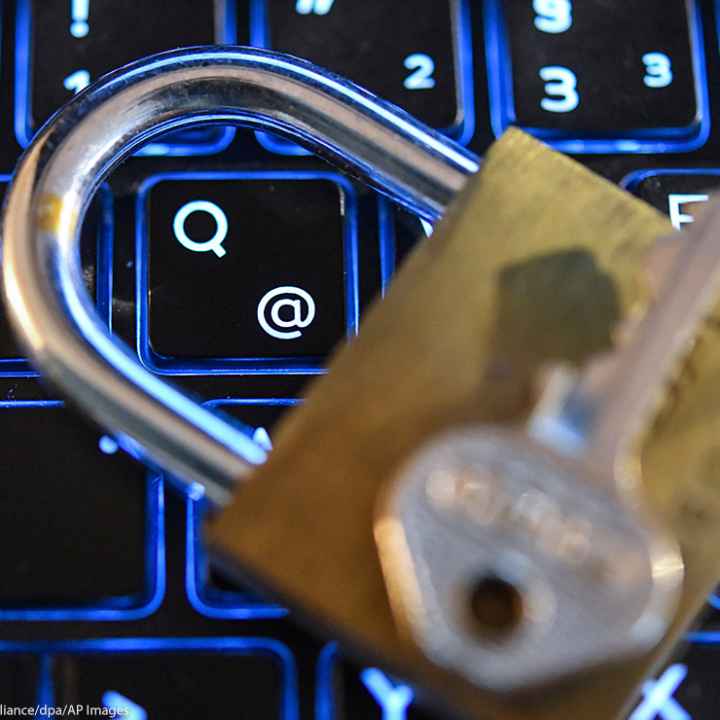 A lock and key on top of a computer keyboard.