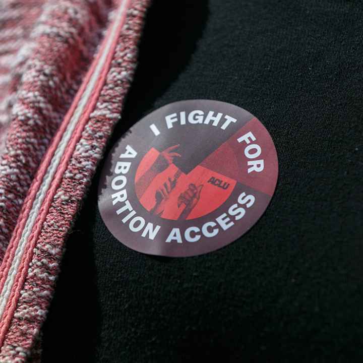 Someone wearing a sticker that says "I Fight For Abortion Access."